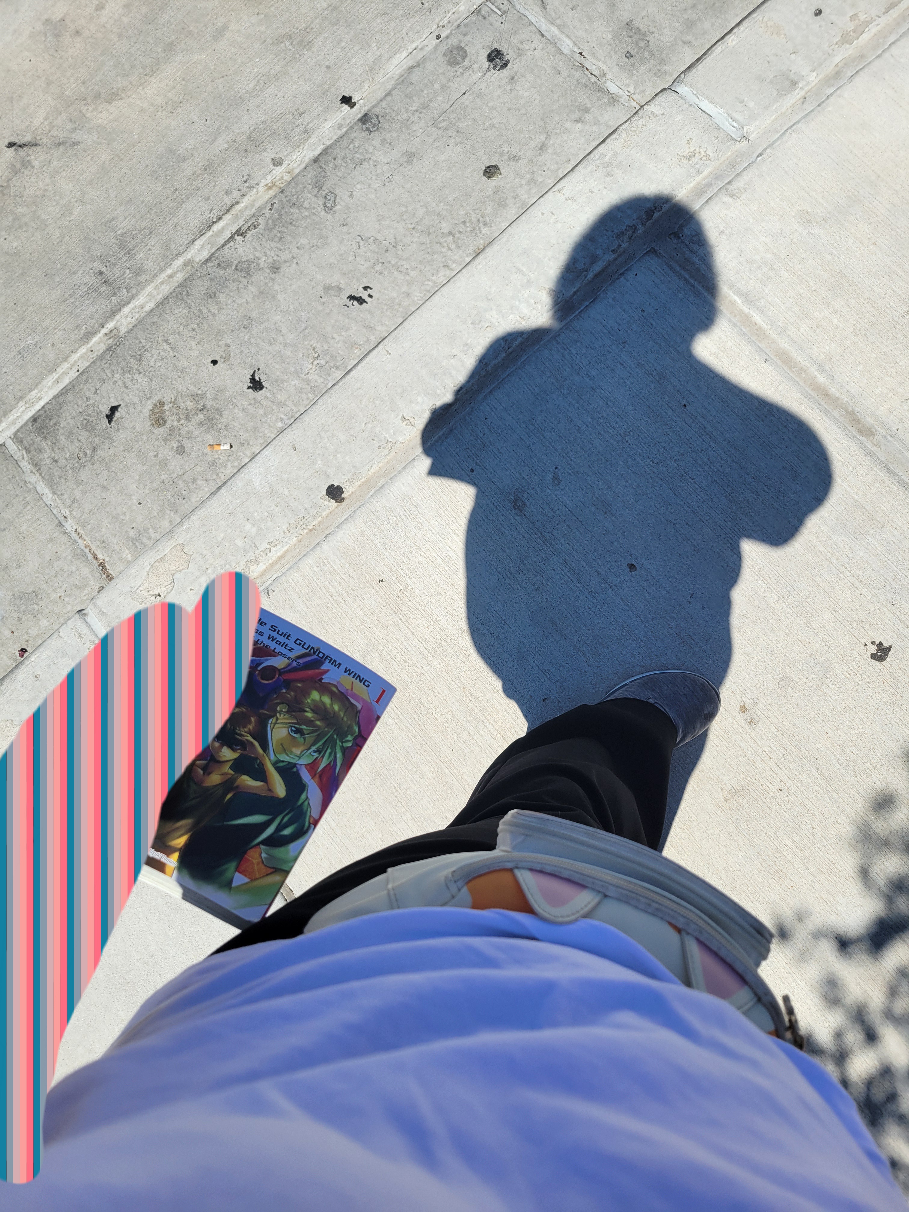 Hand holds Gundam Wing Glory of Losers volume 1 at side.